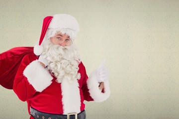 Composite image of santa claus with his sack and thumbs up