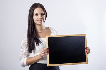 Young businesswoman holding empty chalkboard