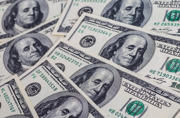 A pile of one hundred US dollar bills on a table
