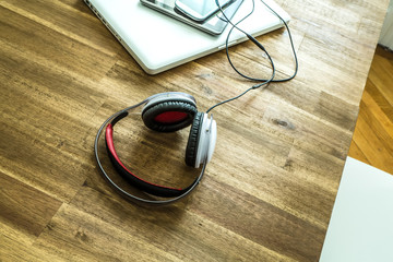Digital devices and Headphones on a wooden Desktop.