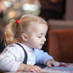 Little girl choosing foood from menu