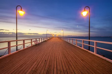 Wall murals The Baltic, Sopot, Poland wooden pier by the sea lit by stylish lamps at night 