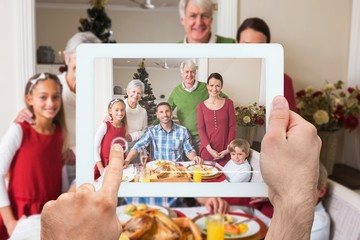 Composite image of hand holding tablet pc