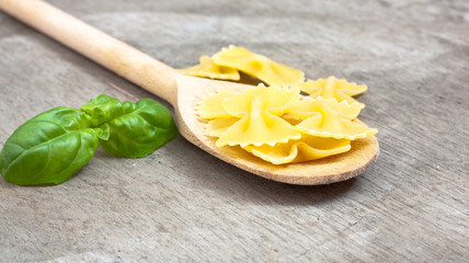 Fine farfalle noodles on wooden board