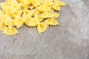 Fine farfalle noodles on wooden board