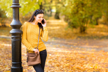 Junge Frau telefoniert im Park mit Handy