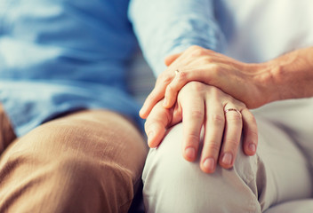 close up of happy male gay couple holding hands