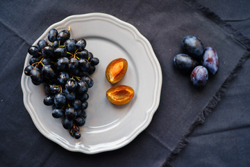 black grapes and plums on a plate