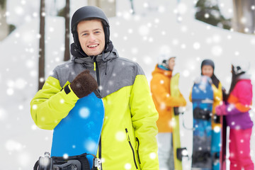 happy friends in helmets with snowboards