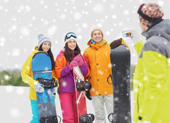 happy friends with snowboards and smartphone