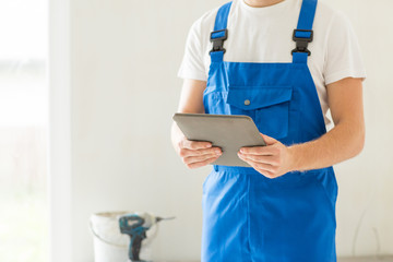 close up of builder or workman with tablet pc
