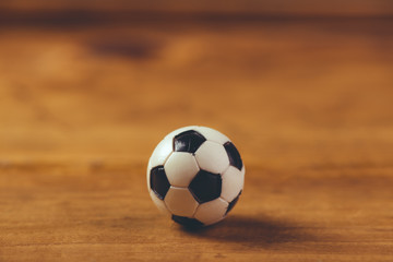 Fototapeta na wymiar Miniature plastic soccer ball on wooden table