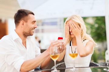 happy couple with engagement ring and wine at cafe