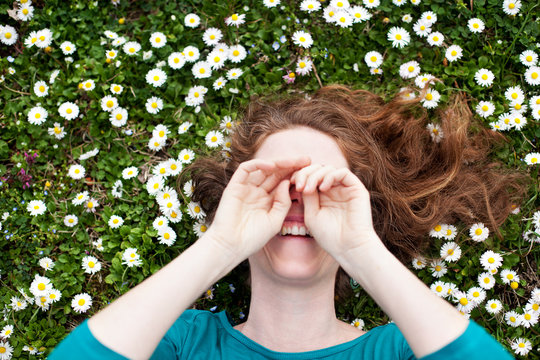 Beautiful Woman Lying Down In Daisy Field