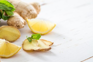 Ginger lemon mint on white wood background