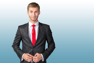 Young handsome businessman adjusting his tie