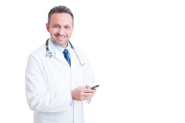 Fototapeta premium Young and friendly doctor or medic texting on smartphone