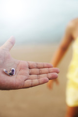 Sea shell in mans hand on the beach