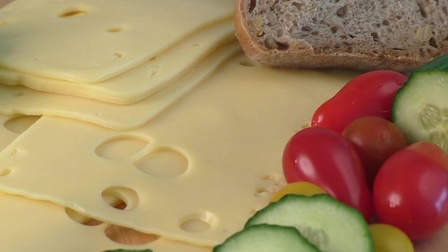 Sliced delicious edam cheese on wooden board  
