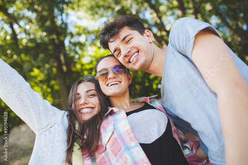 happy teenage friends smiling outdoors on nature handsome young