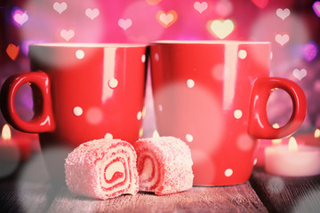 Two cups on table on bright lights background