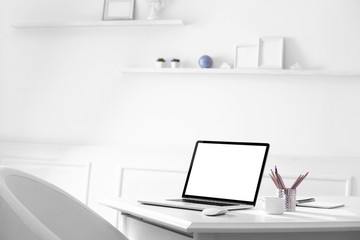 Workplace with laptop in room