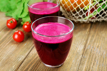Glasses of beet juice with vegetables on table close up