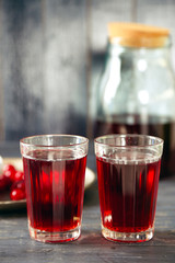 Sweet homemade cherry juice on table, on color wooden background