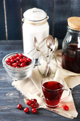 Sweet homemade cherry juice on table, on color wooden background