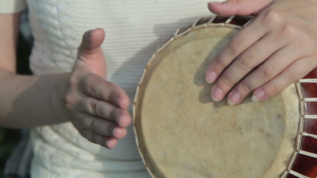 Women playing on Jambe Drum on nature