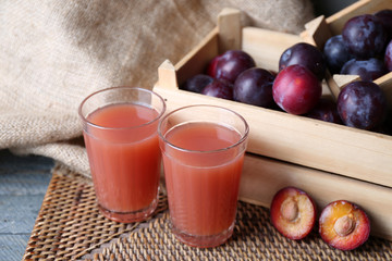 Delicious plum juice with fruits on table close up