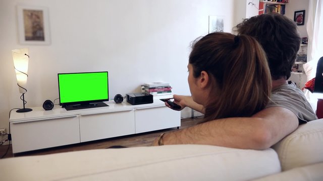 Couple Zapping TV green screen - Full HD. Couple watches television with green screen / shot behind model's shoulders
