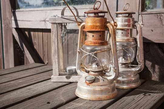Rusted kerosene lamps stands on old wooden table