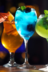 Glasses of cocktail on dark blurred lights background