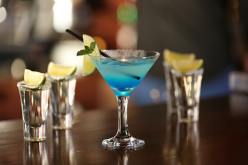 Glasses of cocktails on bar background