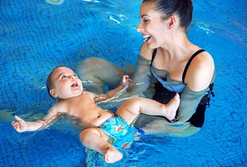 Fototapeten Young mother and baby relaxing in the swimming pool © konradbak