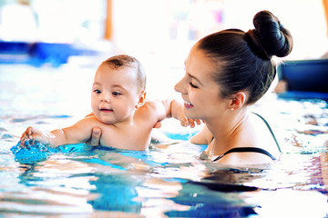 Obraz na płótnie Canvas Mother swimming her cute baby
