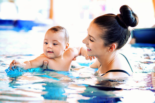 Mother swimming her cute baby