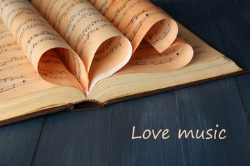 Book pages curved into hearts shapes on table close up