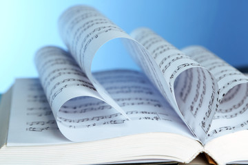 Book pages curved into hearts shapes on blue background