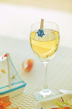 Served table on the sandy beach. Focus on wine glass