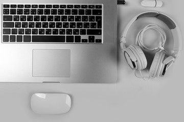 Close-up view of laptop and equipment at working place on silver glossy background