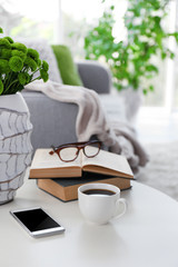 Cup of coffee with books on table in room