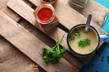 Mug of soup on wooden mat