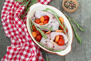 carp steak with rosemary and pepper in a ceramic form