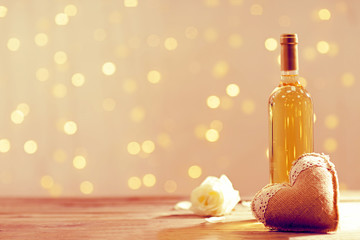Wine bottle with heart on lights background