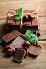 Black chocolate pieces with nuts on wooden background
