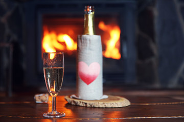 Bottle of wine on table, on fireplace background