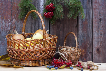 Fototapeta na wymiar Autumn still life with pumpkins in basket and autumn berry on old wooden background, closeup
