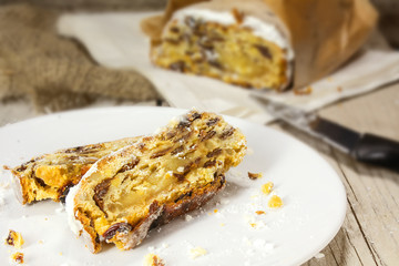 slices of German Christmas stollen on a white plate, the whole s